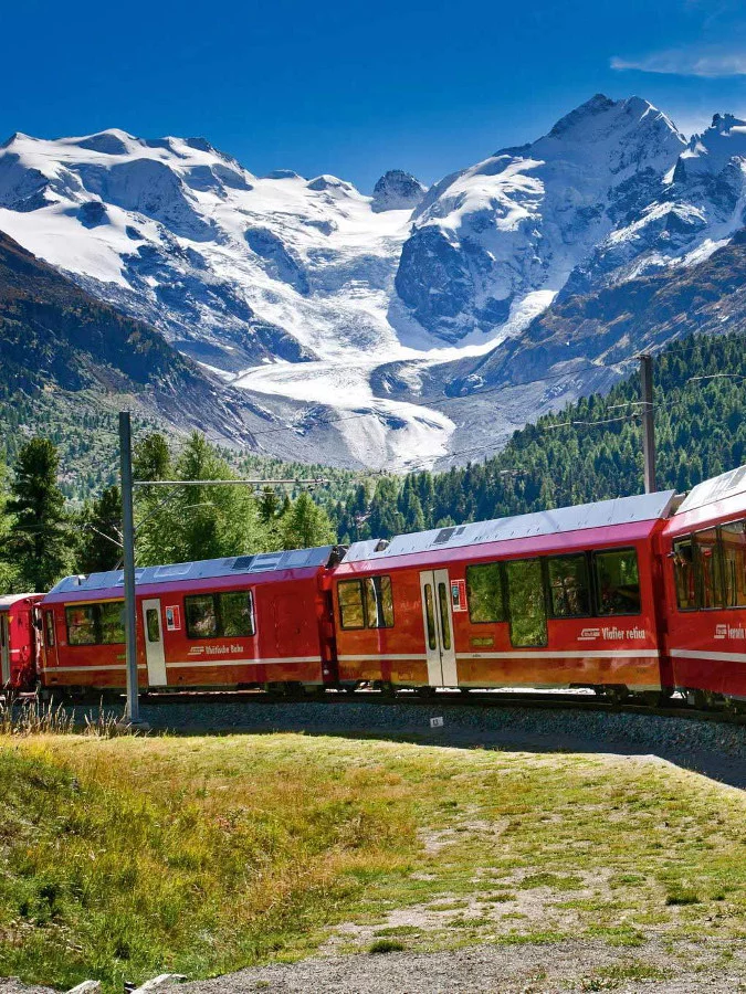 Train of Rhaetian Railway, Bernina Express, in the area of Bernina Massif and Glacier Morteratsch.