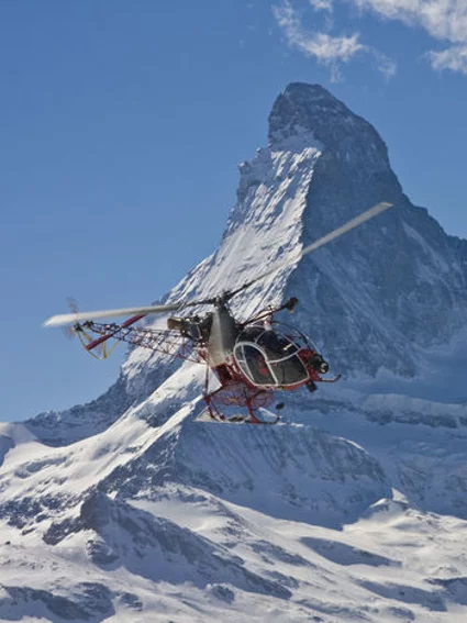 Helicopter in flight, Matterhorn mountain in the background.